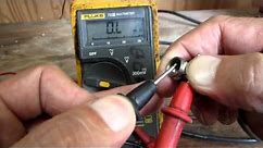 Using a multimeter to check a coax cable.
