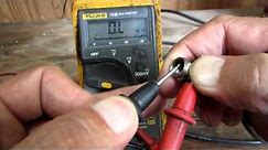 Using a multimeter to check a coax cable.