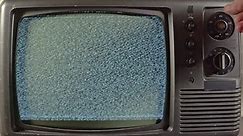 A Hand Is Seaching For A Channel On An Old Tv Camera Zooming Out 1