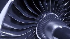 A large jet engine turbine full screen, with a lot of silver blades interconnected to each other and a central silver dome. Energy, power