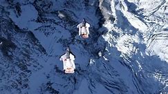 Wingsuit jumpers fly from top of mountain into flying plane in extraordinary stunt