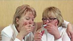 Female smoker. Two senior women smoke cigarettes