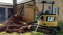 Fixing broken water line with cat excavator tractor