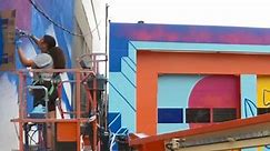 Artist brightens community with mural on auto repair shop ahead of Baltimore's Artscape