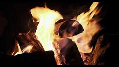 Le bois de chauffage brûle dans le poêle. Énergie thermique au point de combustion. Lumières du feu sur fond noir