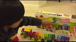 Kid playing with toys Lego Duplo Number Train