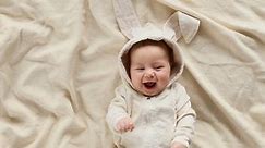 Cute baby smiling and looking in the camera close up. Little kid in Easter bunny costume, top view
