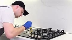 A Qualified Employee of the Gas Service Installs a Gas Stove Repair of the Kitchen Stove