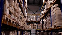 Premium stock video - Aerial factory storage site, warehouse where countless boxes are meticulously arranged on sturdy shelves