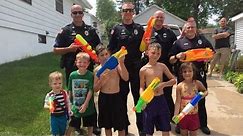 Police Officers Get Soaked In Water Gun Fight With Kids On Hot Summer Day