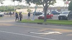 Protesters engage a person outside of Menards