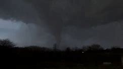 Watch as a tornado moves across the land near Winchester, Ind.